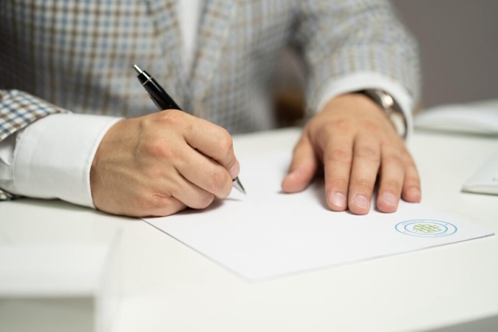 Person signing a form at a desk