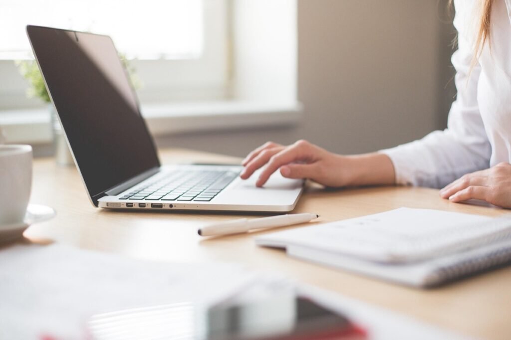 Person working on a laptop at a bright desk
