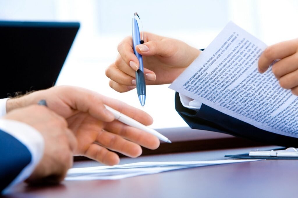 Two people reviewing printed documents with a pen