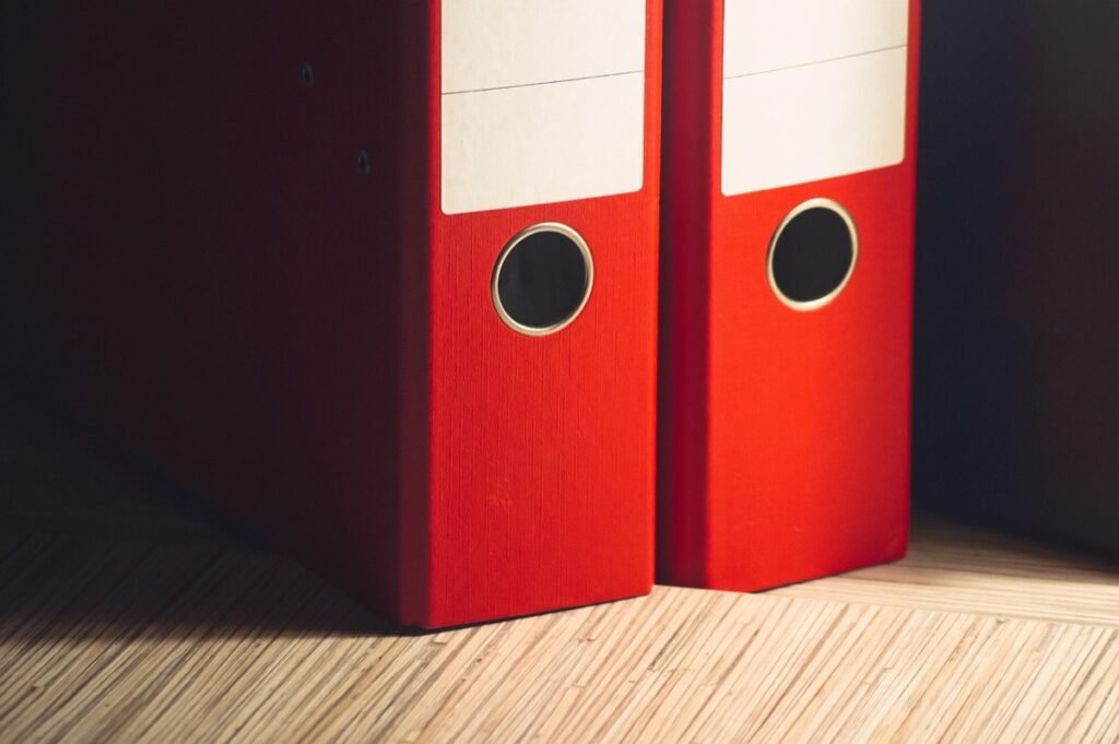 Red binders standing on a wooden surface